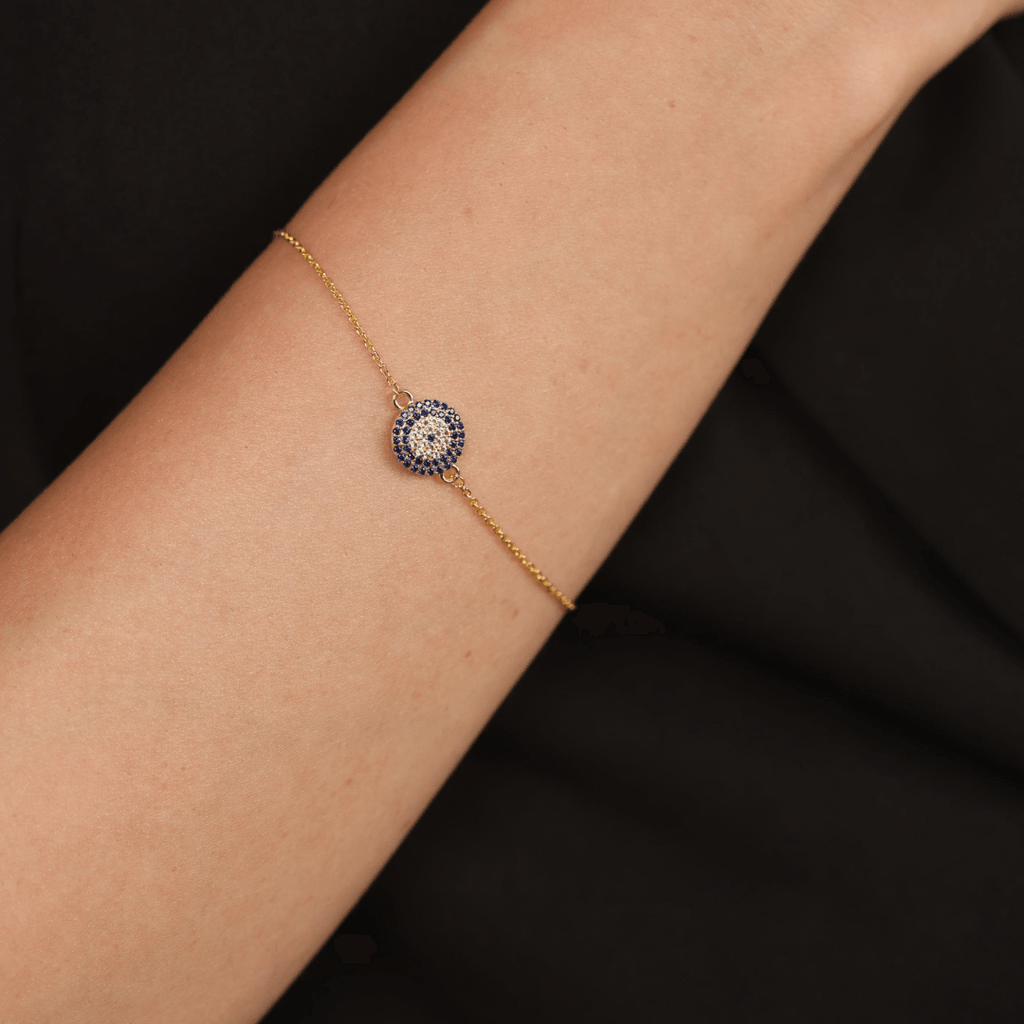 Elegant model hand showcasing the intricate details of our Gold Plated Silver Evil Eye Blue Sapphire Protection Bracelet Evil Eye Guardian Bracelet