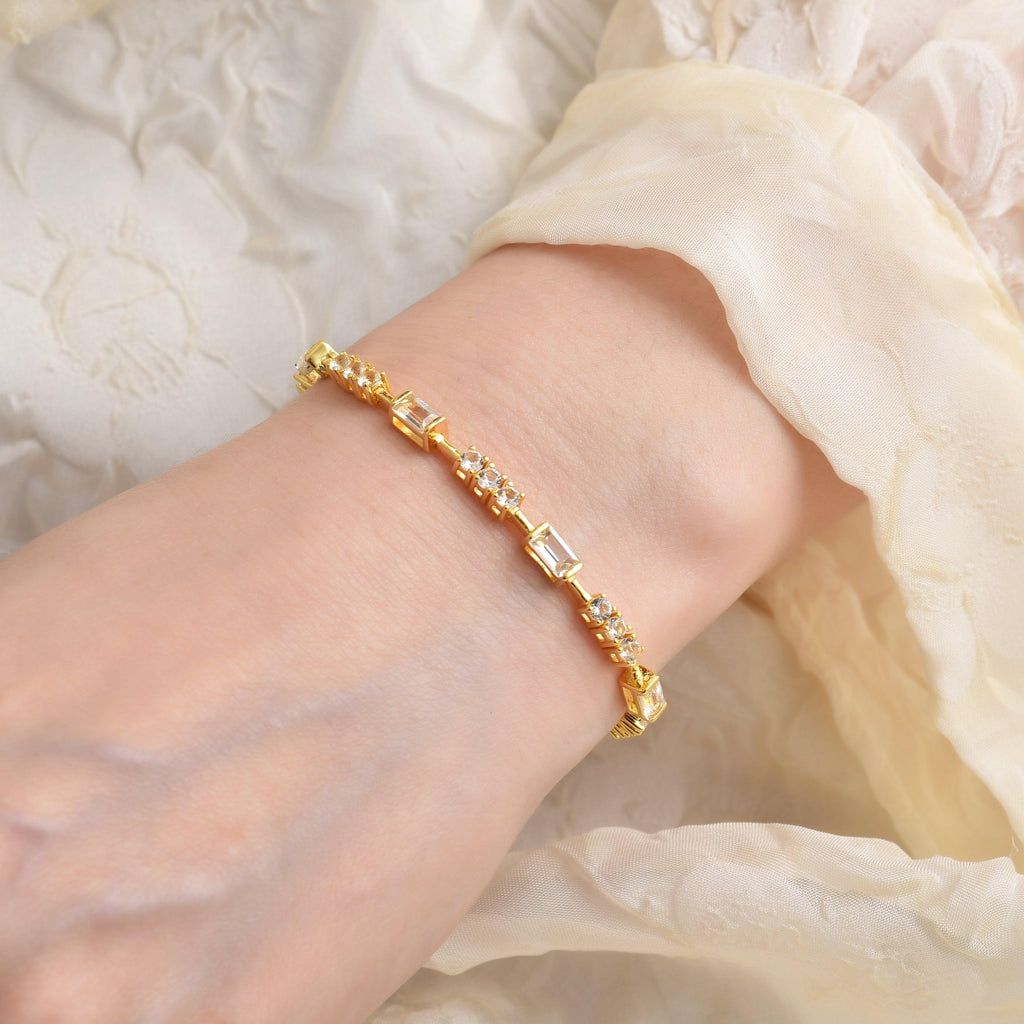 Elegant model hand showcasing the intricate details of our  White Topaz Baguette Bracelet 14k Yellow Gold Plated Dainty Bracelet Bridesmaid Gift Bridal Shower Silver Bracelet Gift for Her