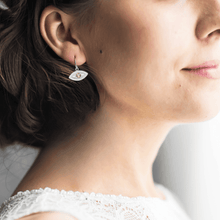 Load image into Gallery viewer, model showcasing peridot earrings leo earrings mal de ojo earrings green eye earrings evil eye earrings silver evil eye dangling evil eye dangling earrings protection earrings evil eye charm silver earrings gift from daughter Leo birthday gift