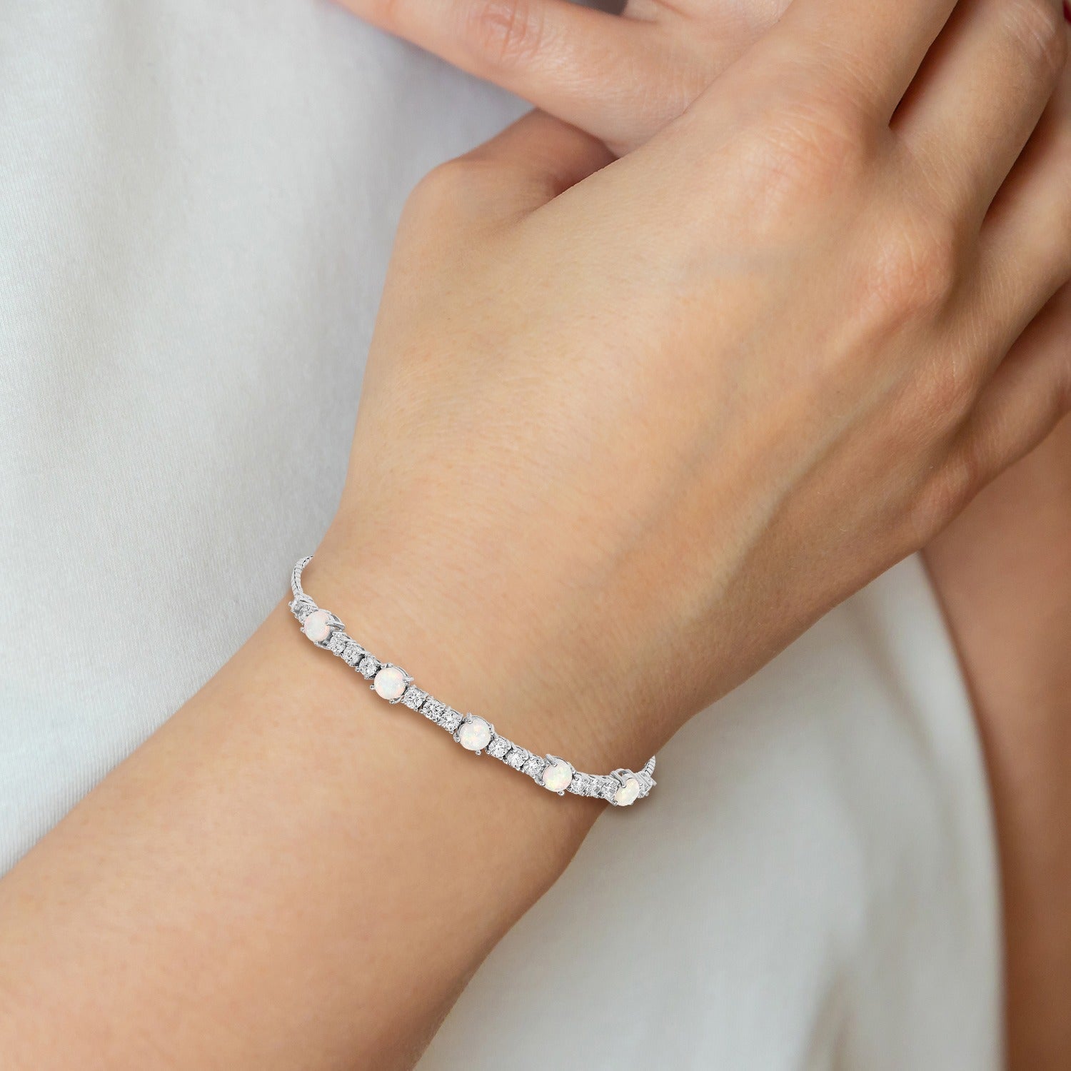 Hand wearing a delicate gemstone and diamond silver bracelet from FCJ Jewelry LLC